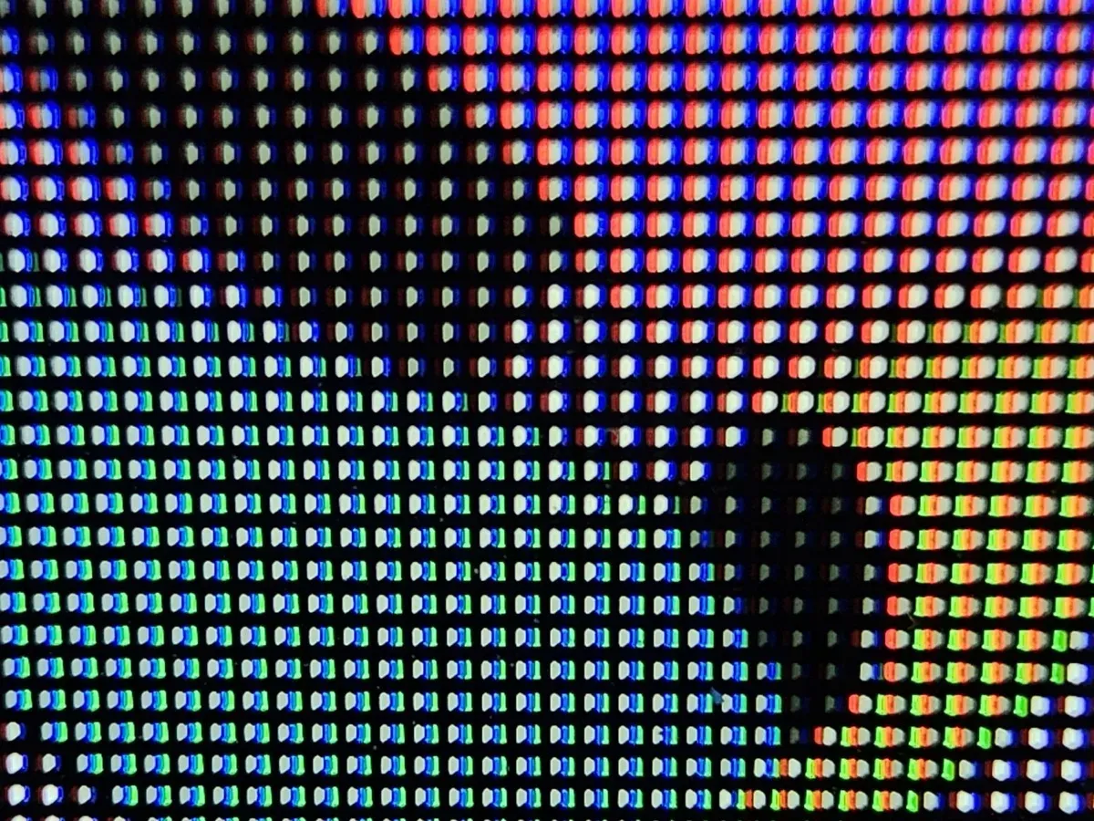 Extreme close-up of an LG C1 OLED TV screen showing rows of red, green, blue, and white subpixels, with a fully black area where the pixels are off